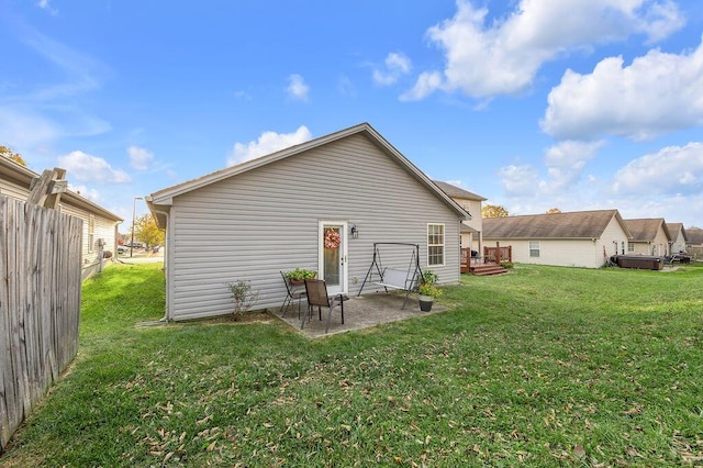 back of house with a patio area and a lawn