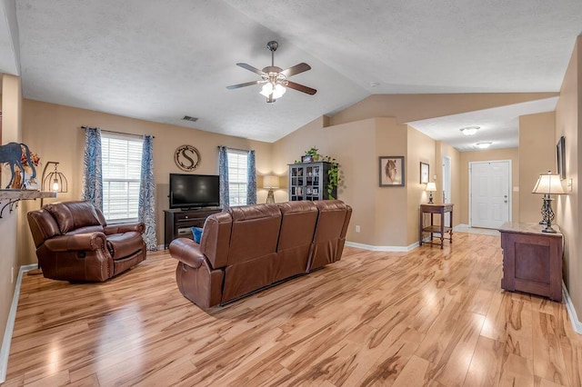 living room featuring ceiling fan, lofted ceiling, and light wood-type flooring