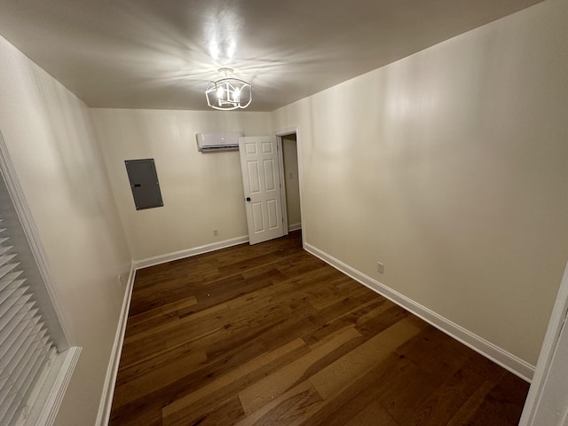 spare room with electric panel, a wall mounted AC, dark hardwood / wood-style flooring, and a chandelier