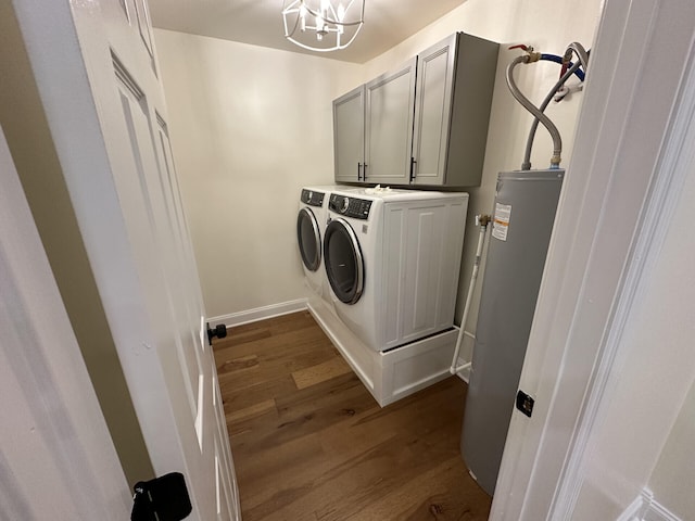 clothes washing area featuring washer and clothes dryer, water heater, a notable chandelier, cabinets, and dark hardwood / wood-style flooring