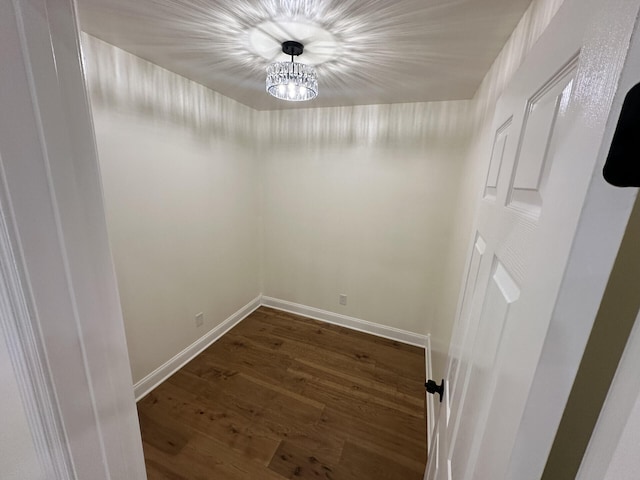 spare room with a chandelier and dark hardwood / wood-style flooring