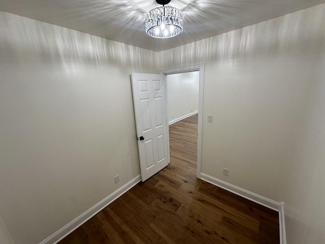 interior space featuring dark wood-type flooring and a notable chandelier