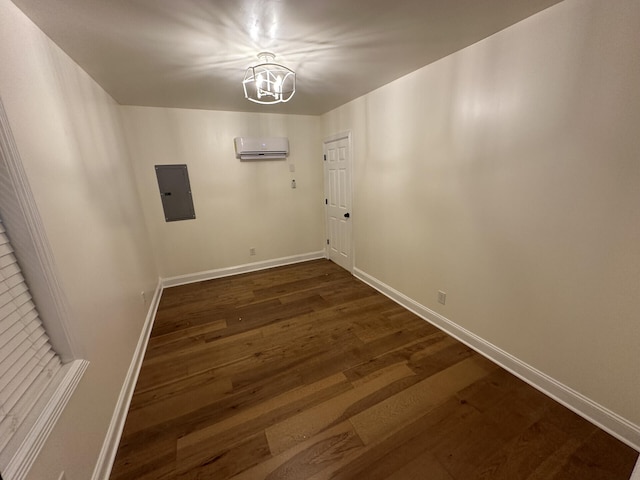 unfurnished room with a wall mounted air conditioner, an inviting chandelier, electric panel, and dark hardwood / wood-style flooring