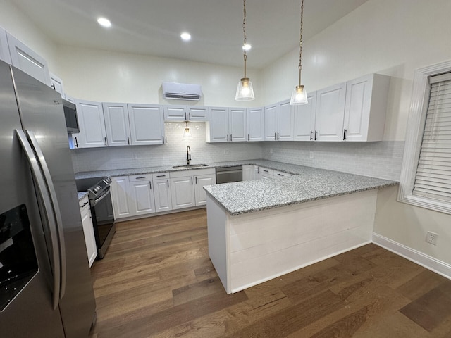 kitchen with dark hardwood / wood-style floors, hanging light fixtures, kitchen peninsula, white cabinets, and appliances with stainless steel finishes