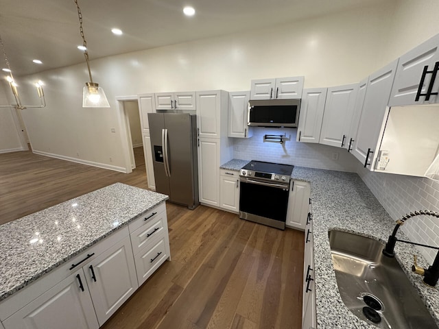 kitchen with dark hardwood / wood-style floors, hanging light fixtures, stainless steel appliances, sink, and white cabinetry