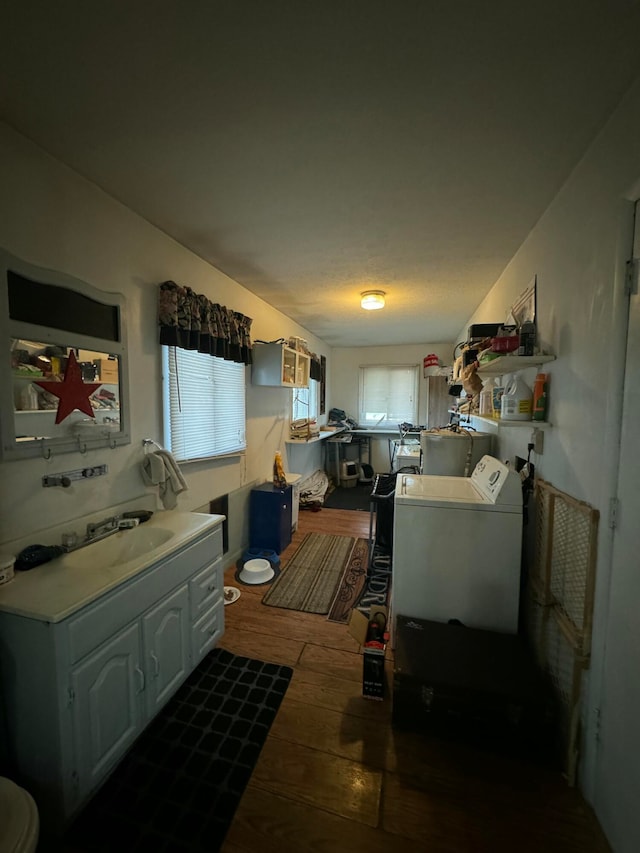 kitchen with white cabinetry, sink, separate washer and dryer, and dark hardwood / wood-style flooring