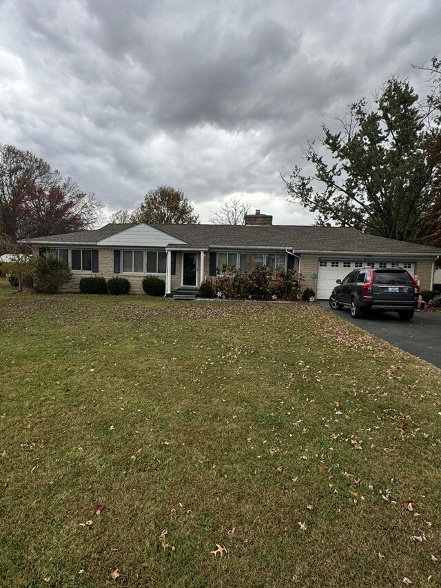 ranch-style home with a garage and a front lawn