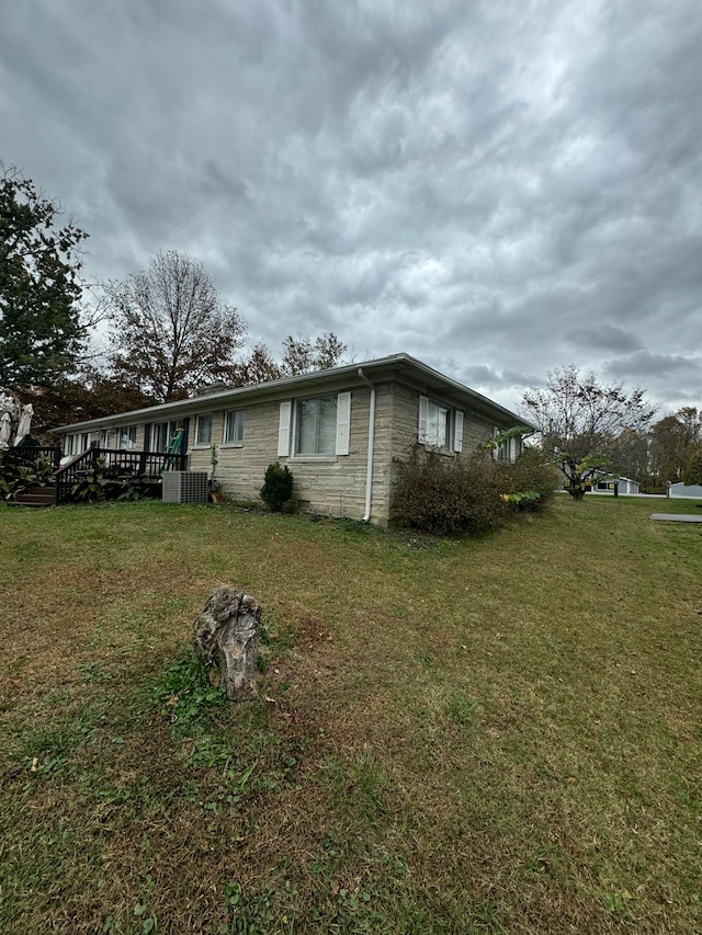 view of home's exterior with a yard and central air condition unit