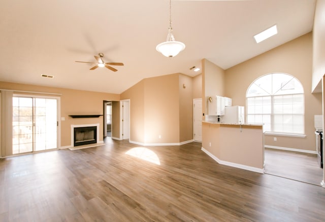 unfurnished living room with ceiling fan, dark hardwood / wood-style floors, and high vaulted ceiling