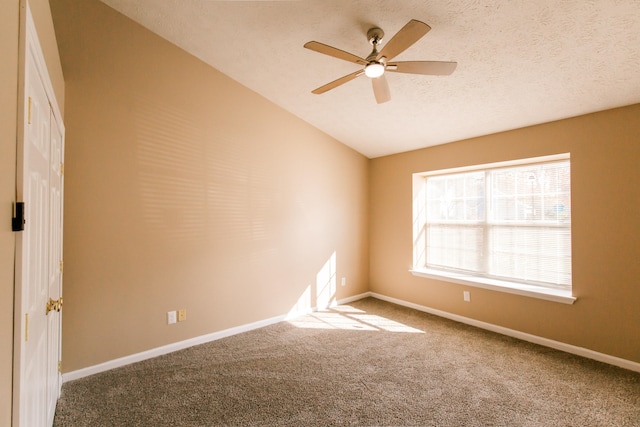 unfurnished room featuring ceiling fan, a textured ceiling, lofted ceiling, and carpet