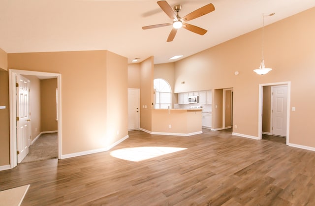 unfurnished living room featuring hardwood / wood-style flooring, ceiling fan, and high vaulted ceiling