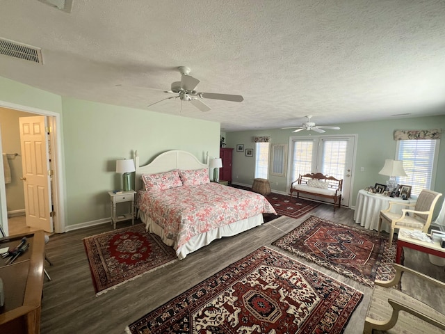 bedroom featuring a textured ceiling, dark hardwood / wood-style floors, and ceiling fan