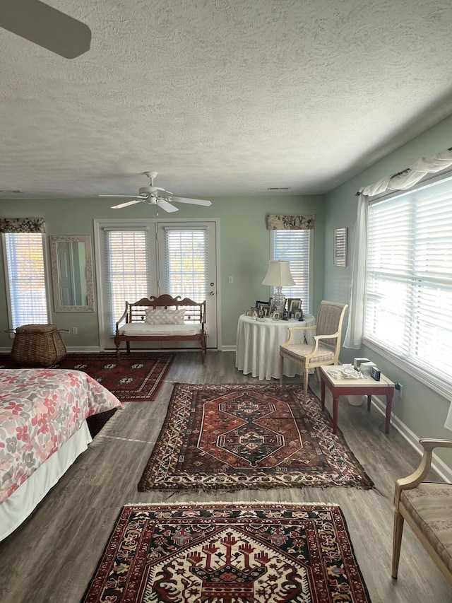 bedroom with a textured ceiling, hardwood / wood-style flooring, and ceiling fan