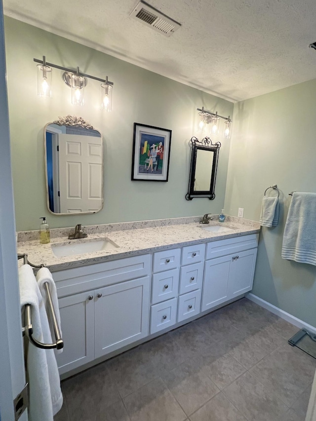 bathroom with vanity, tile patterned floors, and a textured ceiling