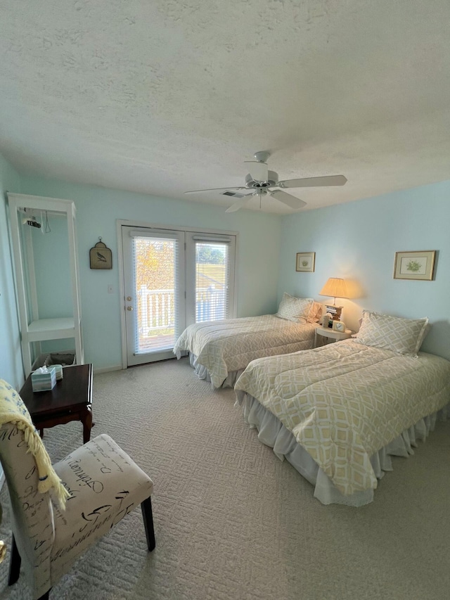 bedroom with ceiling fan, a textured ceiling, carpet floors, and access to exterior