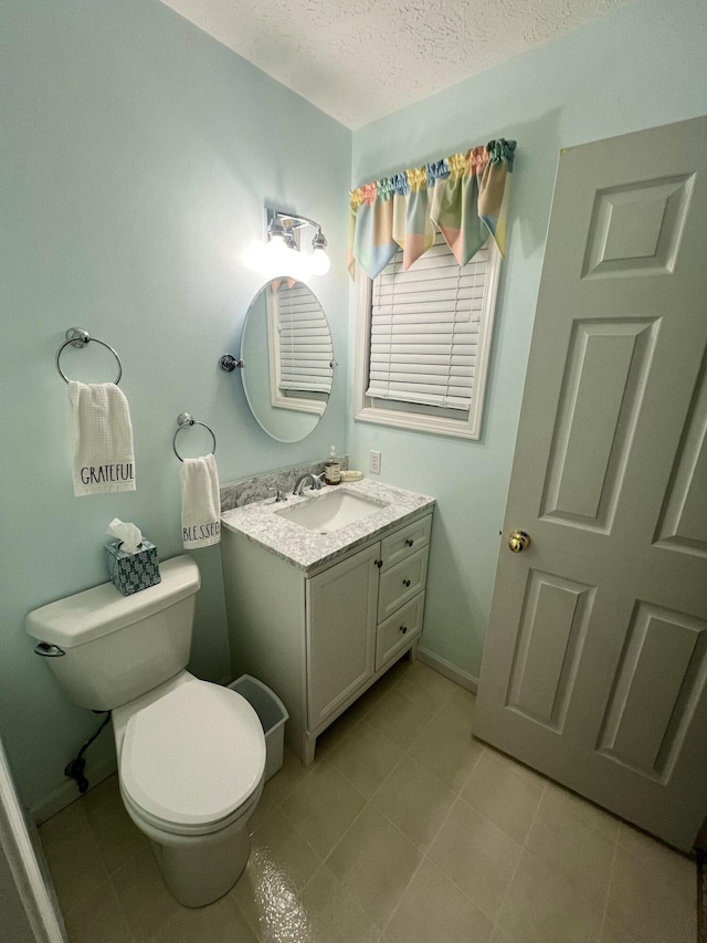 bathroom featuring vanity, a textured ceiling, and toilet