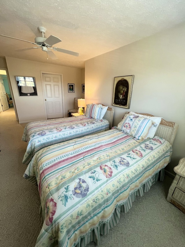 carpeted bedroom featuring a textured ceiling and ceiling fan