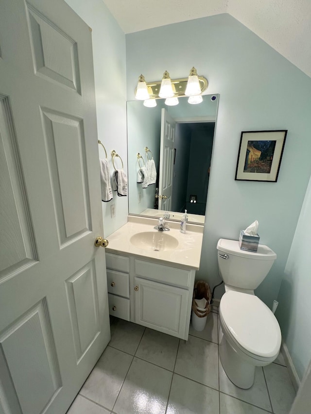 bathroom featuring vanity, toilet, vaulted ceiling, and tile patterned flooring