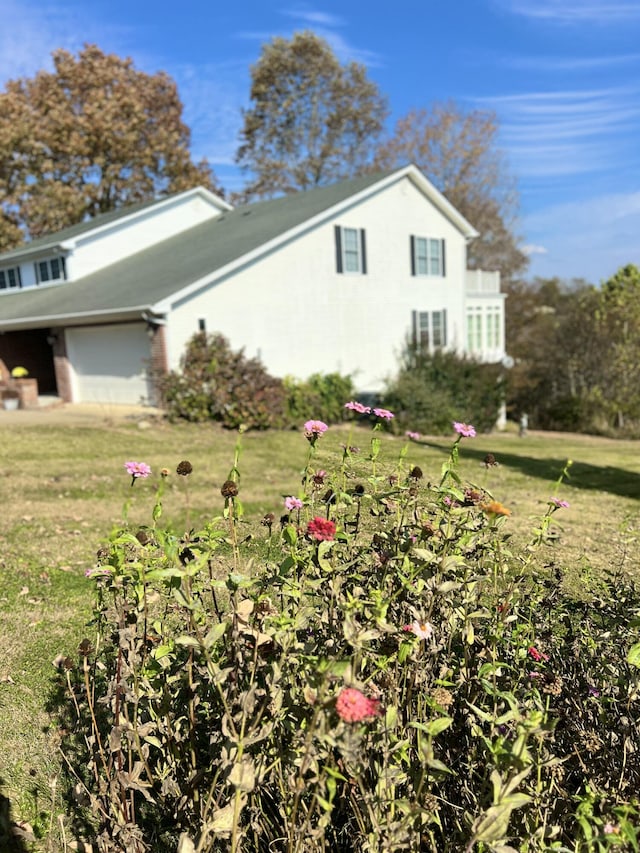 view of side of property with a yard and a garage