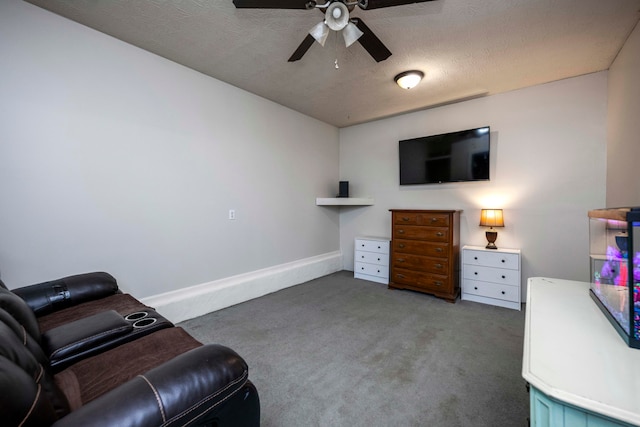 sitting room with dark colored carpet, a textured ceiling, and ceiling fan