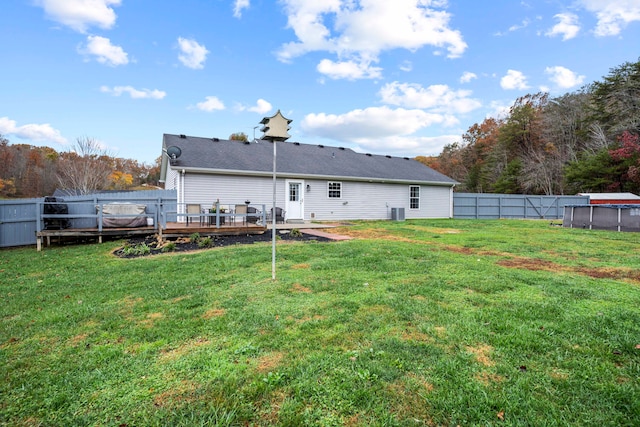 rear view of property featuring a wooden deck and a yard