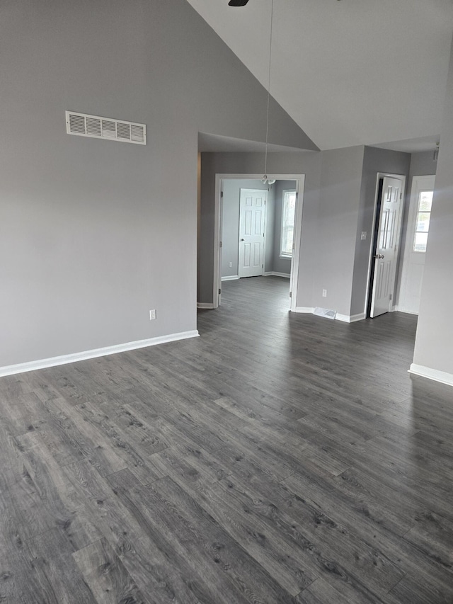 unfurnished living room with dark hardwood / wood-style flooring, high vaulted ceiling, a wealth of natural light, and ceiling fan