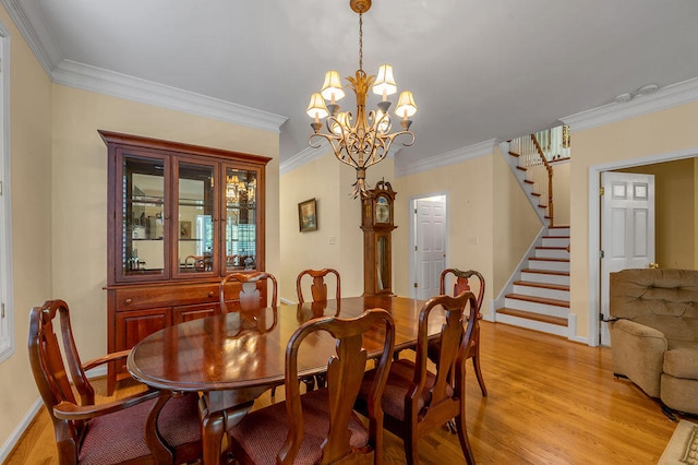 dining room with ornamental molding, light hardwood / wood-style floors, and an inviting chandelier