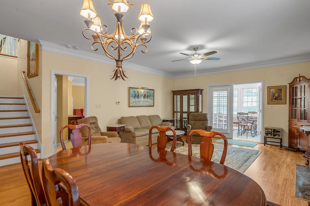 dining room with ceiling fan with notable chandelier, light hardwood / wood-style flooring, and crown molding