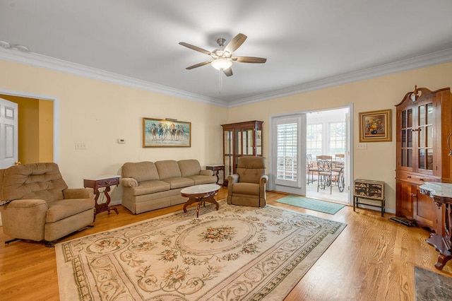 living room featuring ceiling fan, light hardwood / wood-style floors, and ornamental molding