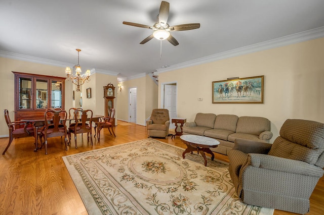 living room featuring ceiling fan with notable chandelier, light hardwood / wood-style flooring, and ornamental molding