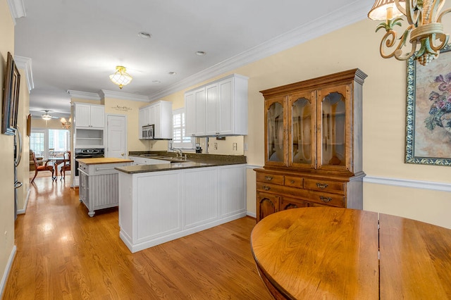 kitchen with wood counters, white cabinetry, and plenty of natural light