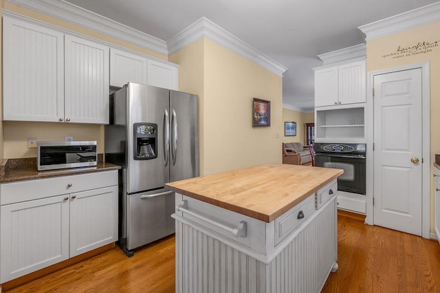 kitchen featuring stainless steel appliances, white cabinets, light hardwood / wood-style flooring, and ornamental molding