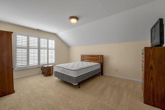 carpeted bedroom with lofted ceiling