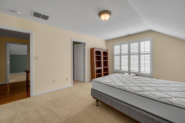 bedroom featuring light colored carpet and lofted ceiling