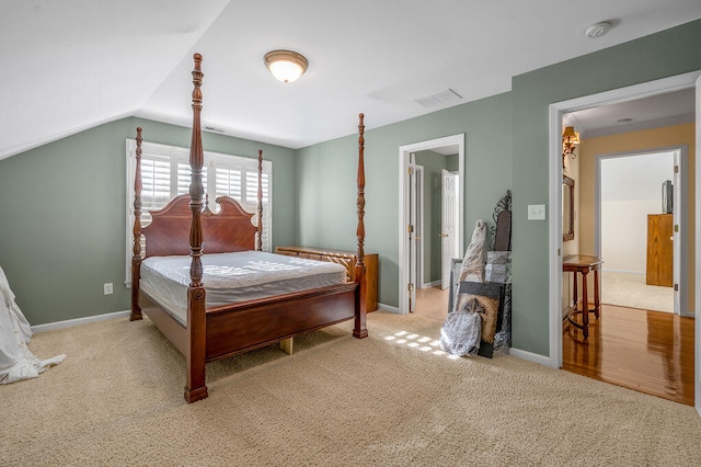 bedroom with lofted ceiling and light carpet