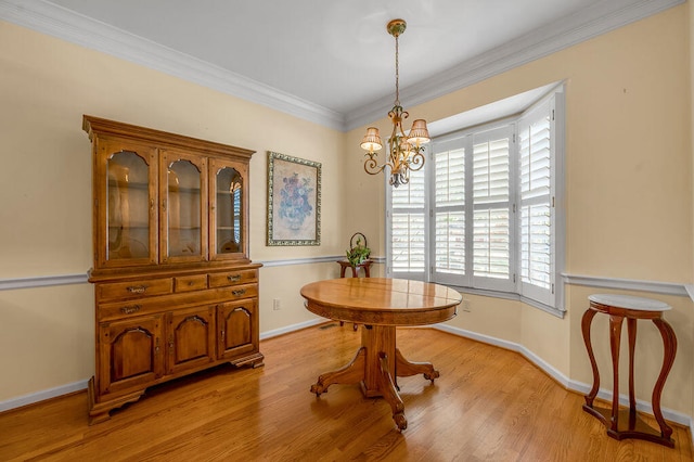 dining space featuring light hardwood / wood-style floors, a chandelier, and ornamental molding