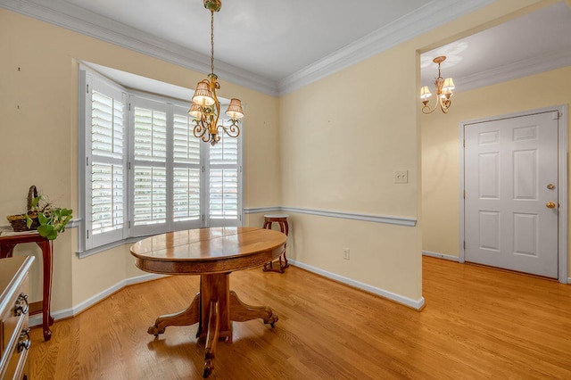 dining area with light wood-type flooring, a chandelier, and ornamental molding