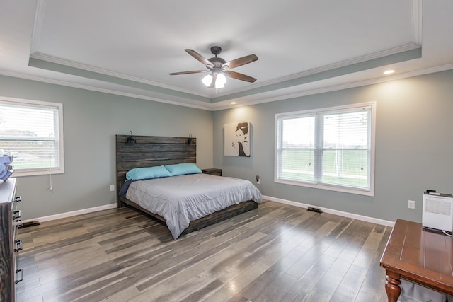 bedroom with ceiling fan, dark hardwood / wood-style floors, a raised ceiling, and ornamental molding