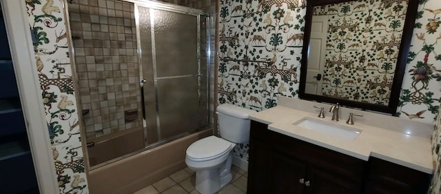 full bathroom with toilet, bath / shower combo with glass door, vanity, and tile patterned flooring