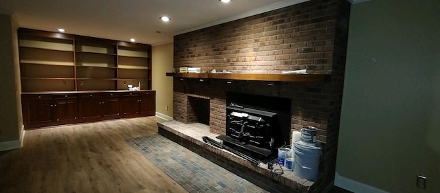 living room featuring a brick fireplace, light wood-type flooring, and ornamental molding