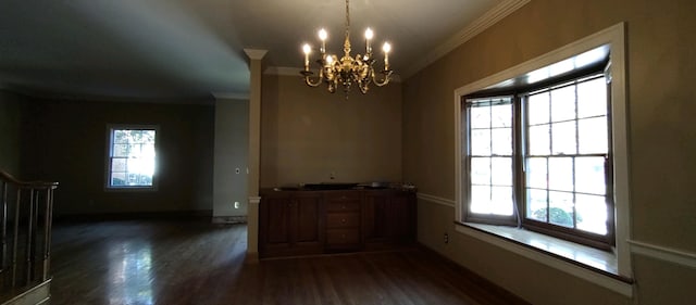 unfurnished dining area with dark wood-type flooring, a wealth of natural light, and ornamental molding