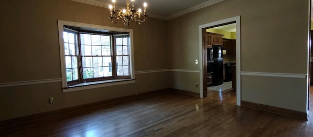 spare room featuring a notable chandelier, dark hardwood / wood-style flooring, and ornamental molding