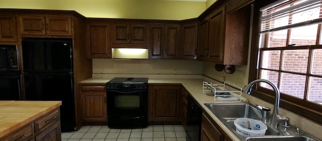 kitchen featuring light tile patterned flooring, extractor fan, sink, black appliances, and butcher block countertops