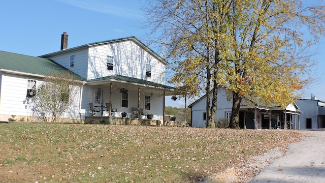 view of front of house featuring a front lawn, covered porch, and a garage