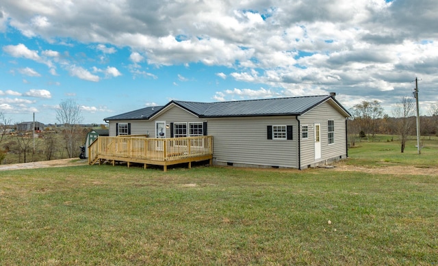 back of property with a wooden deck and a yard