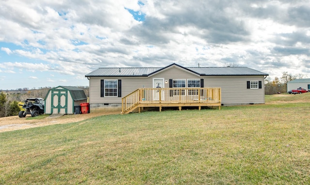 rear view of house with a wooden deck, a shed, and a lawn