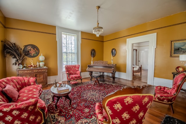 sitting room featuring wood-type flooring and an inviting chandelier