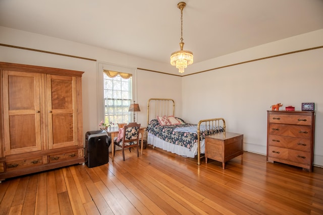 bedroom featuring hardwood / wood-style flooring and an inviting chandelier