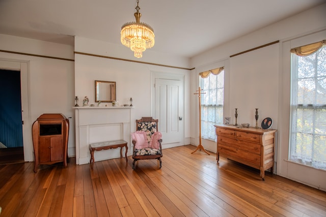 living area with hardwood / wood-style floors, a chandelier, and plenty of natural light