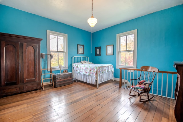 bedroom with multiple windows and light wood-type flooring